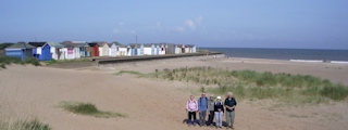 Five of our group in front of beach chalets on Chapel St Leonards beach.
